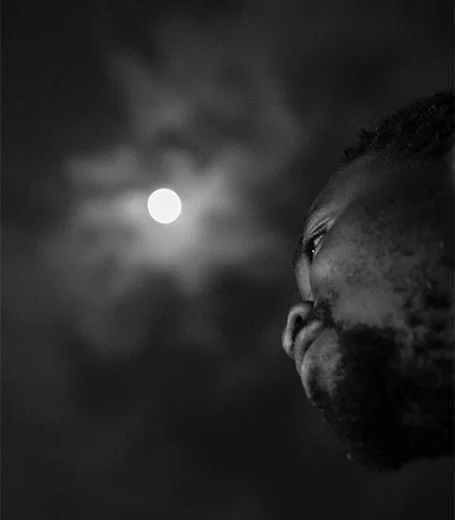 African youth leader contemplating under moonlight - Yole Africa empowerment through art